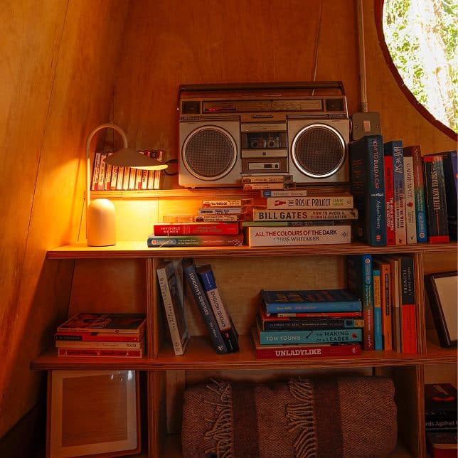 Cucu's bookshelf and cassette player, glowing warm in evening light.