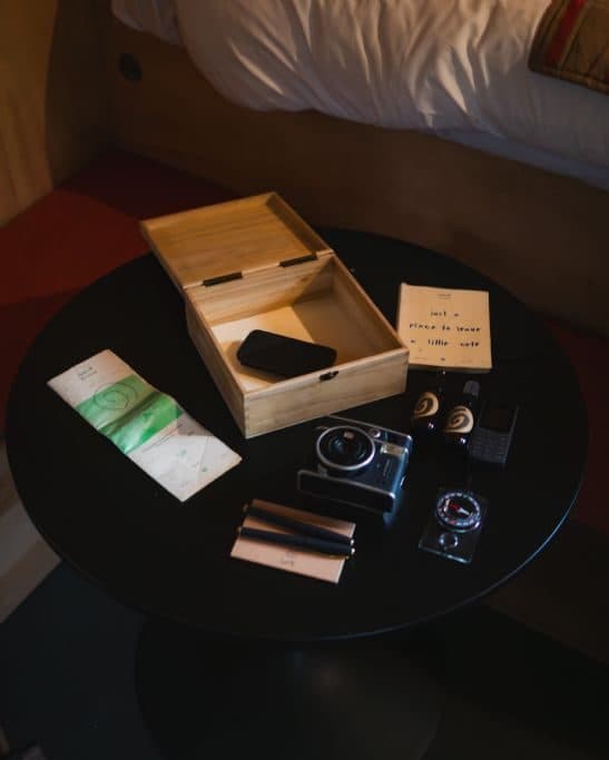 The analogue kit laid out on a table: a wooden box, film camera, cassettes and a handwritten note.